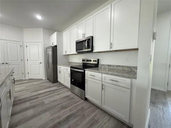 a kitchen with white cabinets and stainless steel appliances