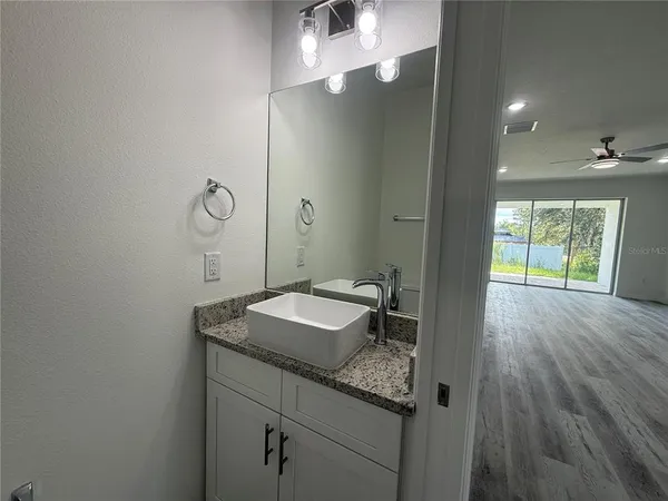 a bathroom with a granite countertop sink toilet and mirror
