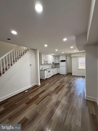 a view of kitchen with kitchen island wooden floor center island and stainless steel appliances