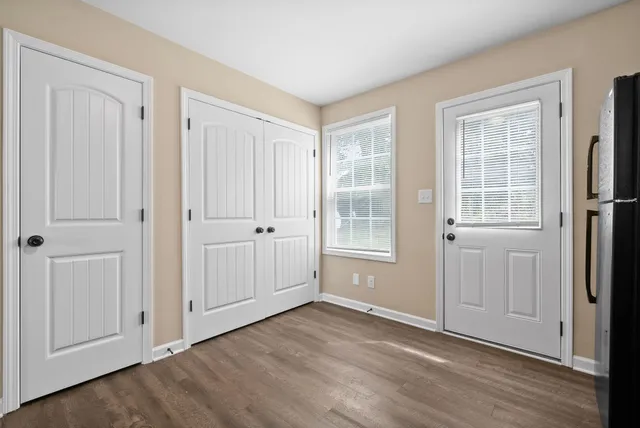 an empty room with wooden floor and windows