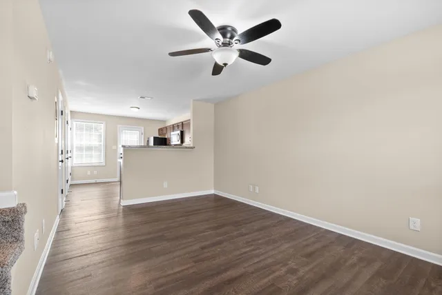 a view of a kitchen with wooden floor and a ceiling fan