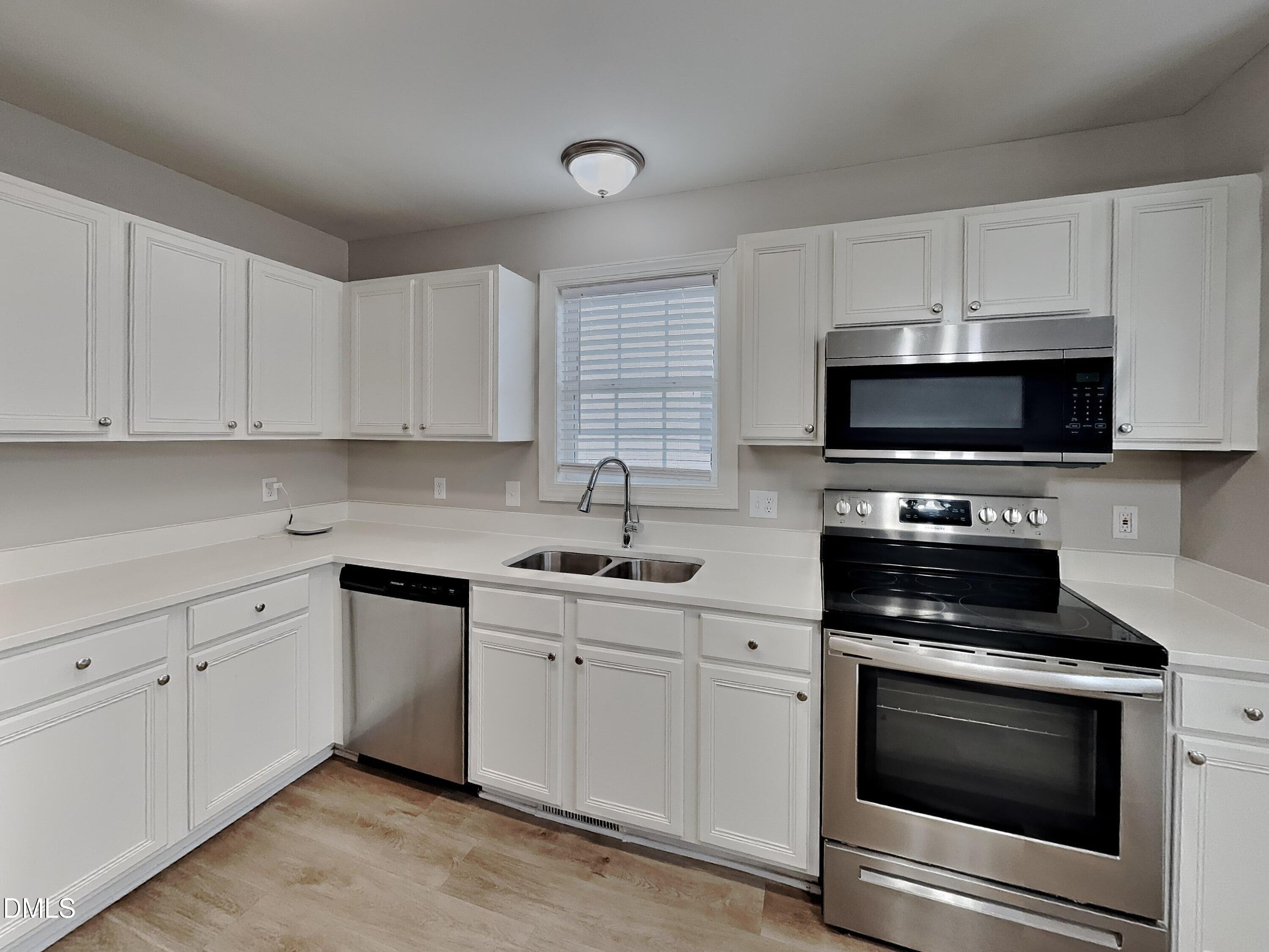 3224 Cotton Grove Raleigh, NC 27610 - Photo 4 of 15 a kitchen with white cabinets and stainless steel appliances