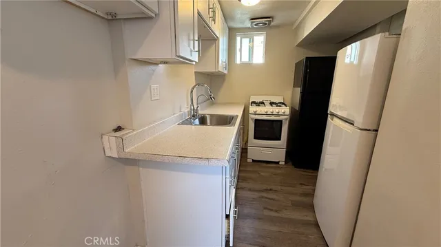 a kitchen with a sink a refrigerator and washer