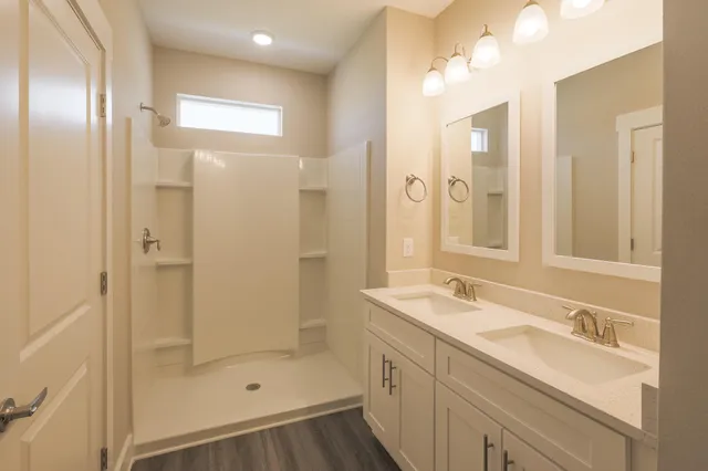 a bathroom with a shower sink and mirror