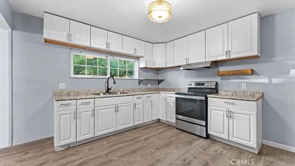 a kitchen with granite countertop white cabinets and white appliances