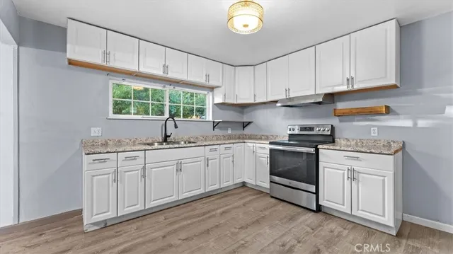 a kitchen with granite countertop white cabinets and white appliances