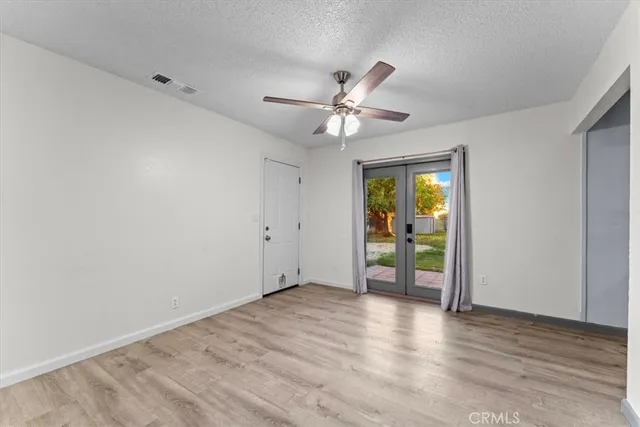 a view of an empty room with window and wooden floor