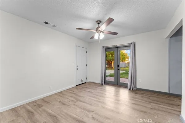a view of an empty room with window and wooden floor