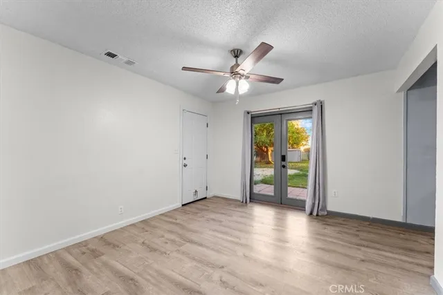 a view of an empty room with window and wooden floor