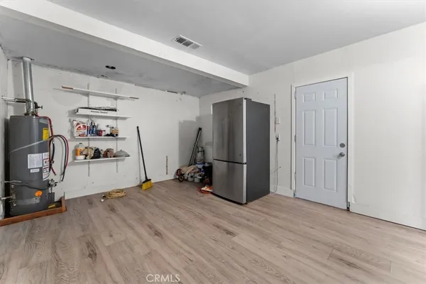 a view of a storage & utility room with refrigerator and toys