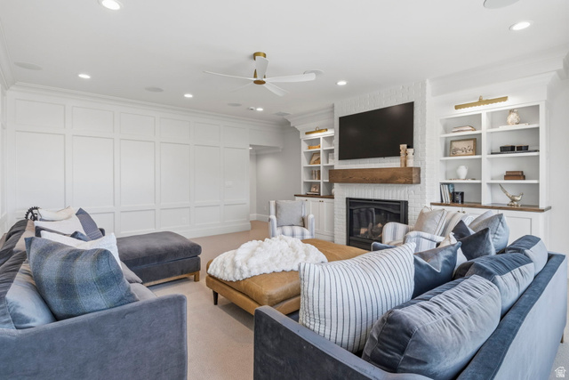 115 East Hidden Ridge Lane, Unit 42 Mapleton, UT 84664 - Photo 42 of 103 Living area featuring a white brick fireplace with a wood-finish mantel, built-in shelving with wood-finish countertops, recessed lighting, and a ceiling fan