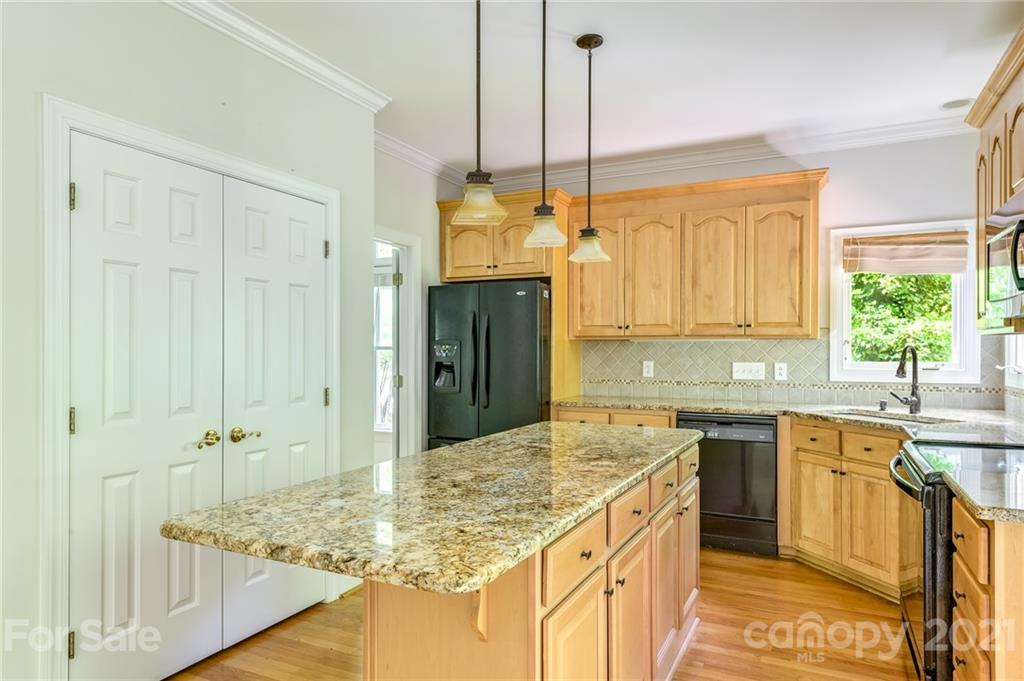 712 Lochaven Road Waxhaw, NC 28173 - Photo 11 of 38 a kitchen with stainless steel appliances granite countertop a sink a stove and a wooden floors