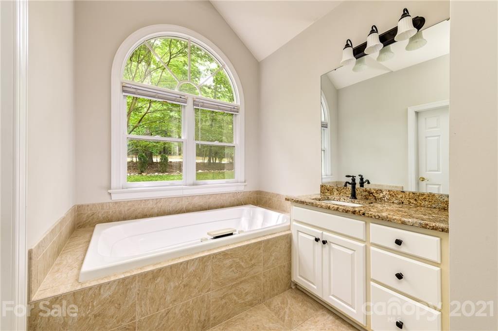 712 Lochaven Road Waxhaw, NC 28173 - Photo 16 of 38 a bathroom with a tub sink and mirror
