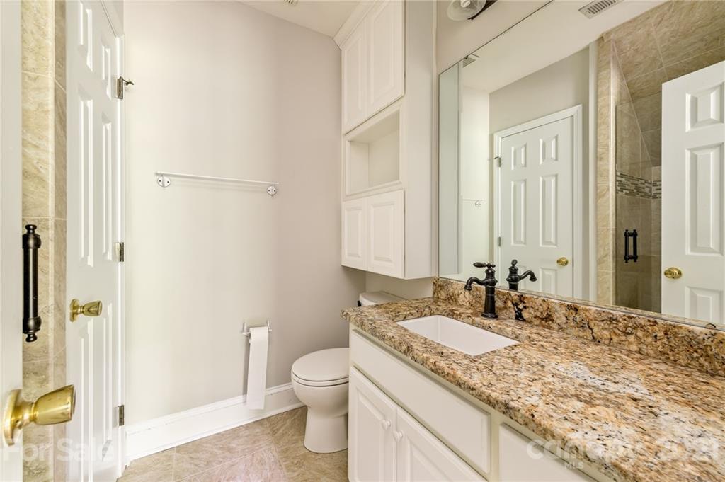 712 Lochaven Road Waxhaw, NC 28173 - Photo 19 of 38 a bathroom with a granite countertop sink toilet and shower