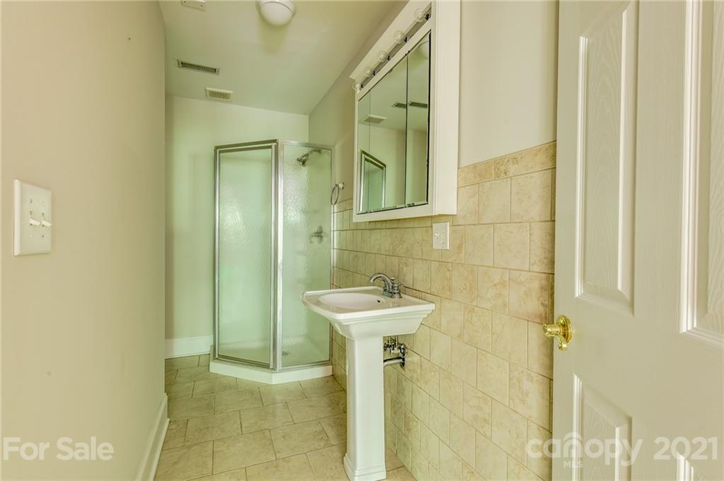 712 Lochaven Road Waxhaw, NC 28173 - Photo 23 of 38 a bathroom with a sink a mirror and shower