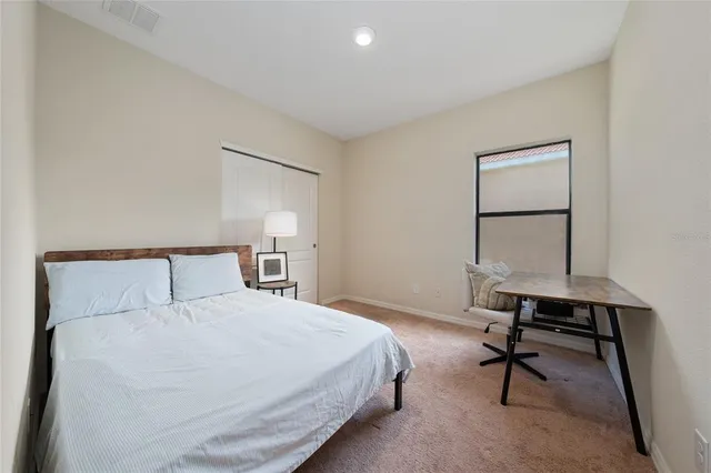 a bedroom with a large bed and a desk