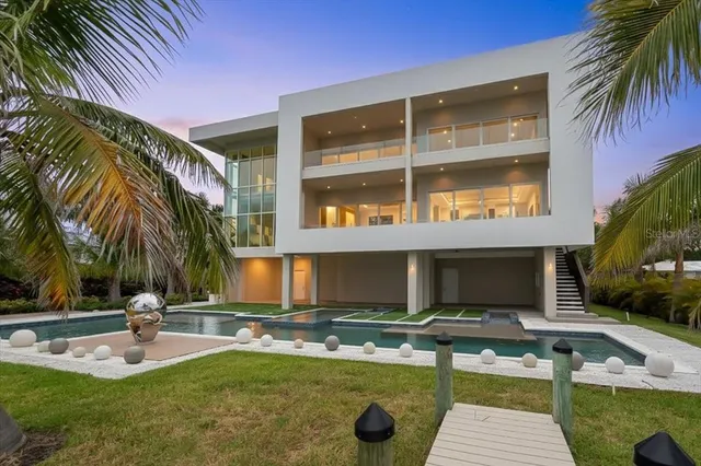 a front view of a house with a yard and palm trees