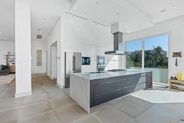 a kitchen with stainless steel appliances kitchen island granite countertop a lot of cabinets a stove and a sink