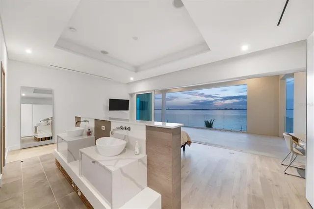 a spacious bedroom with a bed and a flat screen tv