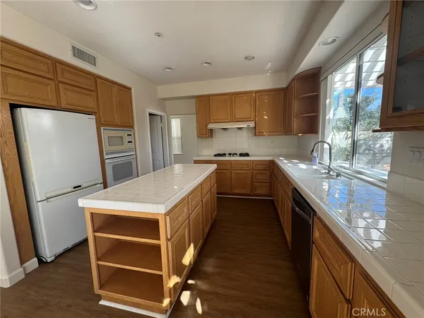 a kitchen with a sink appliances a counter space and a window