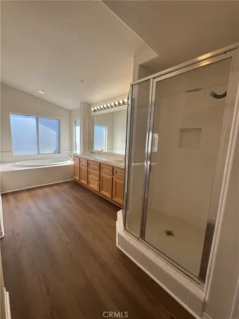 a bathroom with a glass door shower and a sink