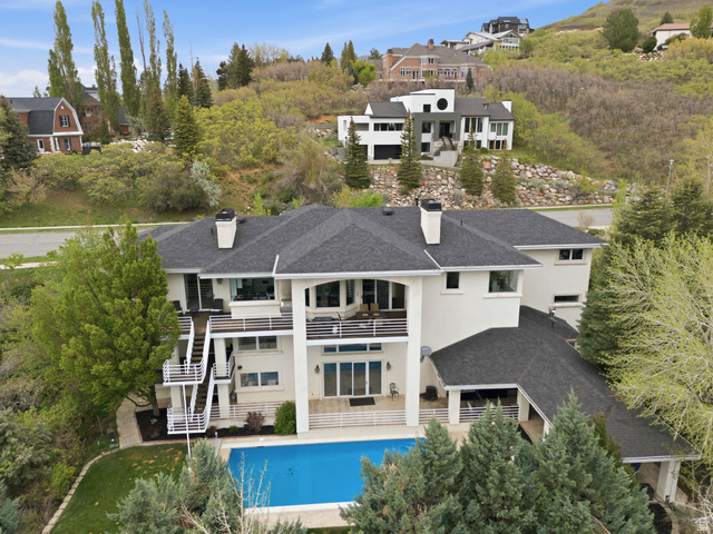 1878 East Ridge Point Drive Bountiful, UT 84010 - Photo 78 of 92 Rear view of house featuring a balcony, a patio area, a chimney, and a shingled roof