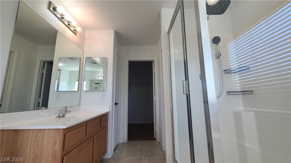 8944 Rutherford Grove Street Las Vegas, NV 89148 - Photo 19 of 35 A well-appointed bath features a spacious vanity with an integrated sink and a sleek glass-enclosed shower.