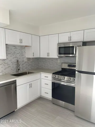 a kitchen with stainless steel appliances granite countertop a stove a sink and a refrigerator