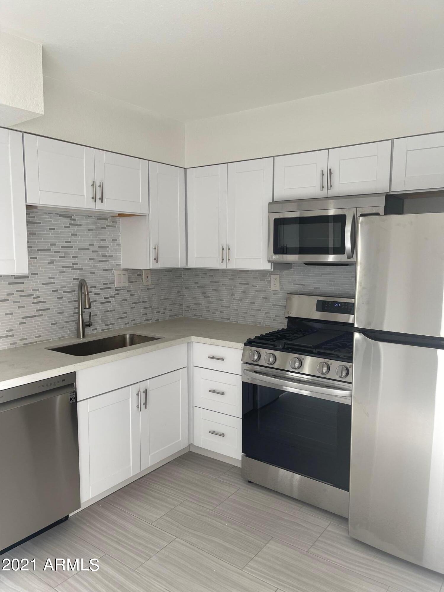 a kitchen with stainless steel appliances granite countertop a stove a sink and a refrigerator