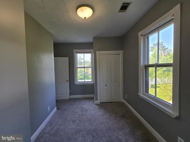 an empty room with a window and a ceiling fan