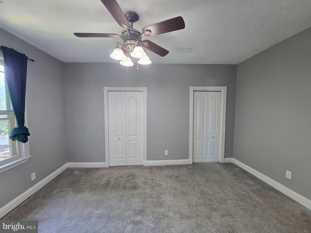 a view of a livingroom with a ceiling fan and window