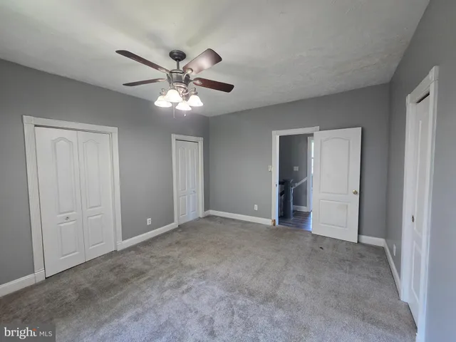 a view of a livingroom with a ceiling fan and window