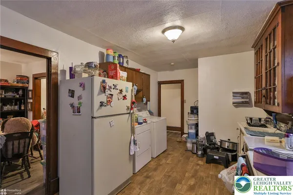 a kitchen with a refrigerator a stove a sink dishwasher and cabinets with wooden floor