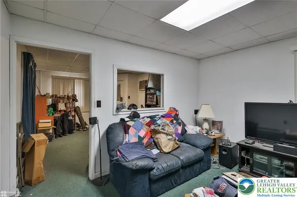 a bedroom with a bed a flat screen tv and dresser