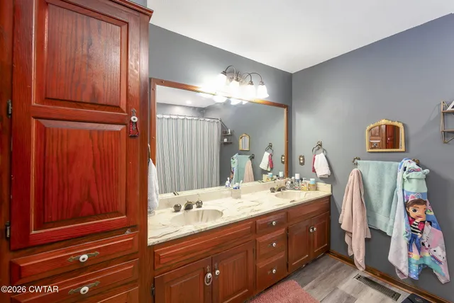 a spacious bathroom with a double vanity sink and a mirror