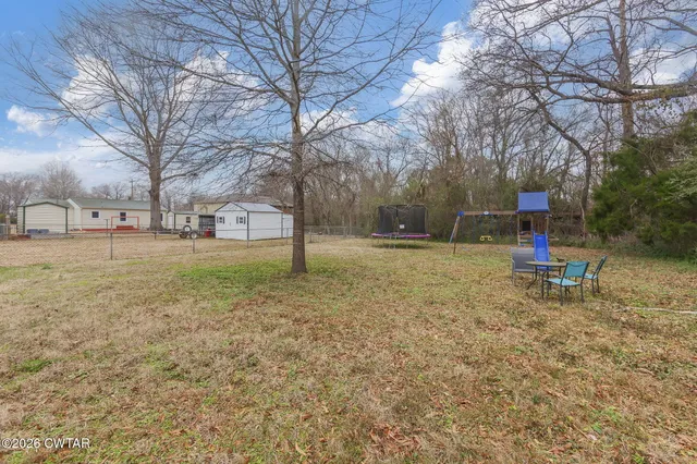 a backyard of a house with table and chairs