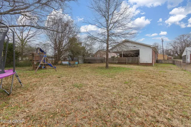 a view of a backyard with a table and chairs