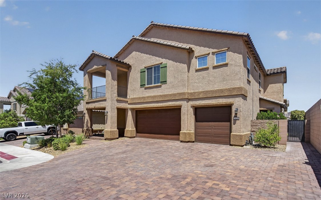 1824 Redland Ridge Street Henderson, NV 89002 - Photo 3 of 69 A spacious paver driveway welcomes you to this modern stucco residence, featuring a second-floor balcony and dual garage access.