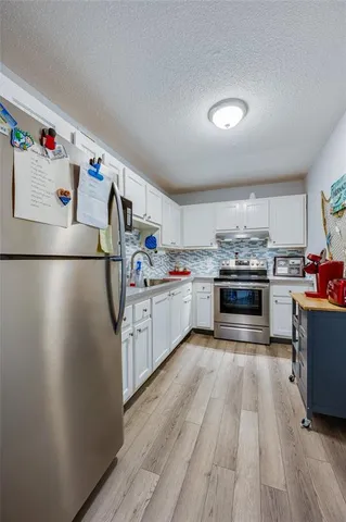 a kitchen with stainless steel appliances a white stove top oven and a refrigerator