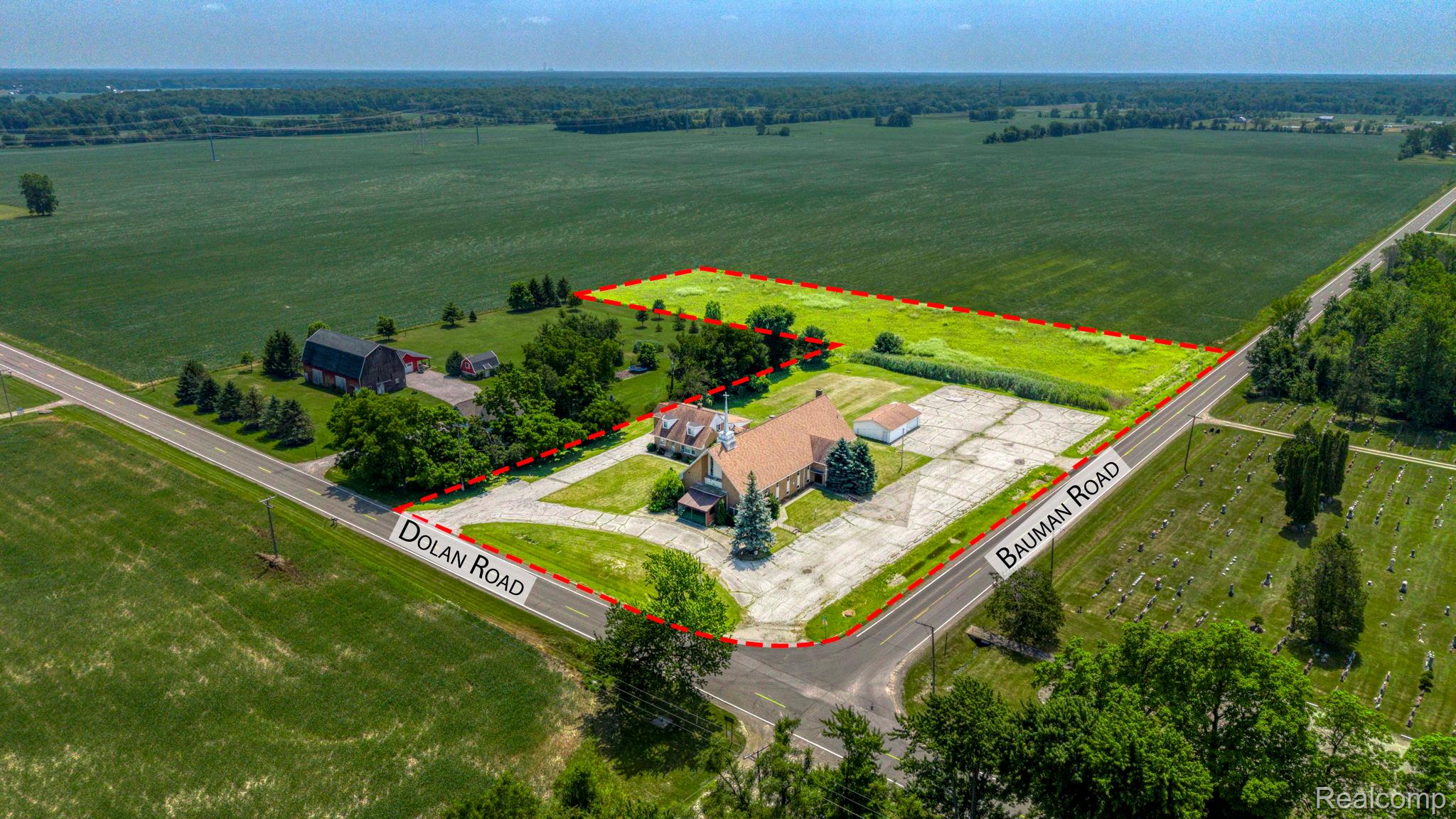 9735 Dolan Road Columbus, MI 48063 - Photo 1 of 63 Expansive corner lot featuring a large building with a gabled roof, extensive paved parking, and direct frontage on two roadways