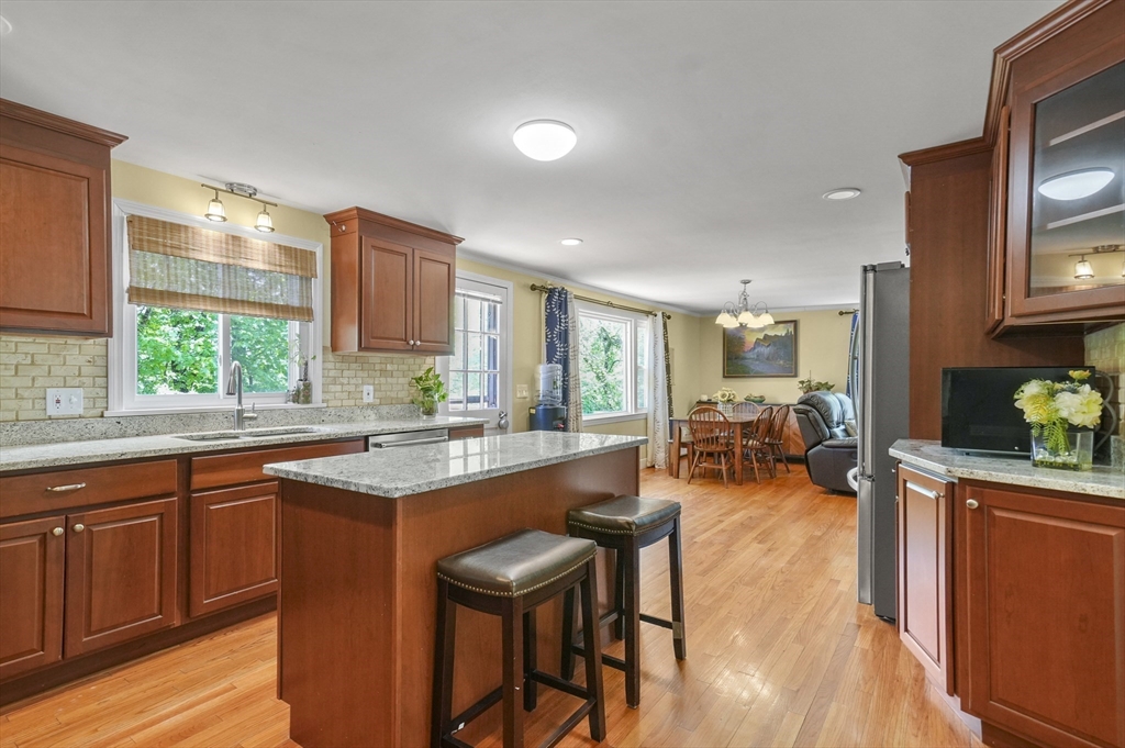 36 Duggan Road Acton, MA 01720 - Photo 10 of 40 a kitchen with sink a stove and chairs with wooden floor