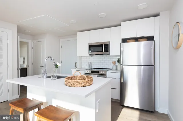 a kitchen with a refrigerator a stove a microwave and dining table