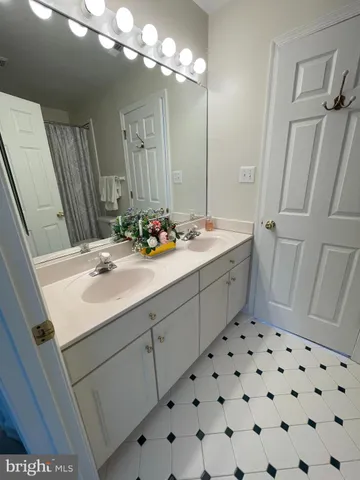 a bathroom with a sink vanity granite and a mirror