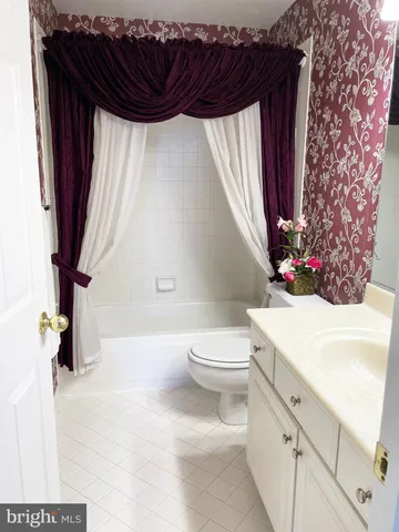 a bathroom with a sink a toilet and a shower curtain