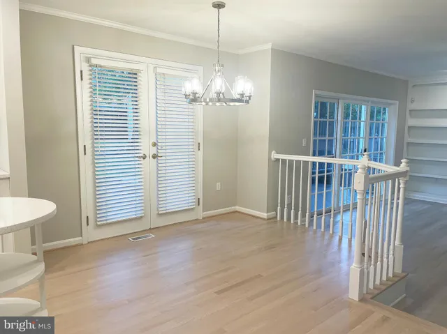 a view of a livingroom with a chandelier wooden floor and a chandelier