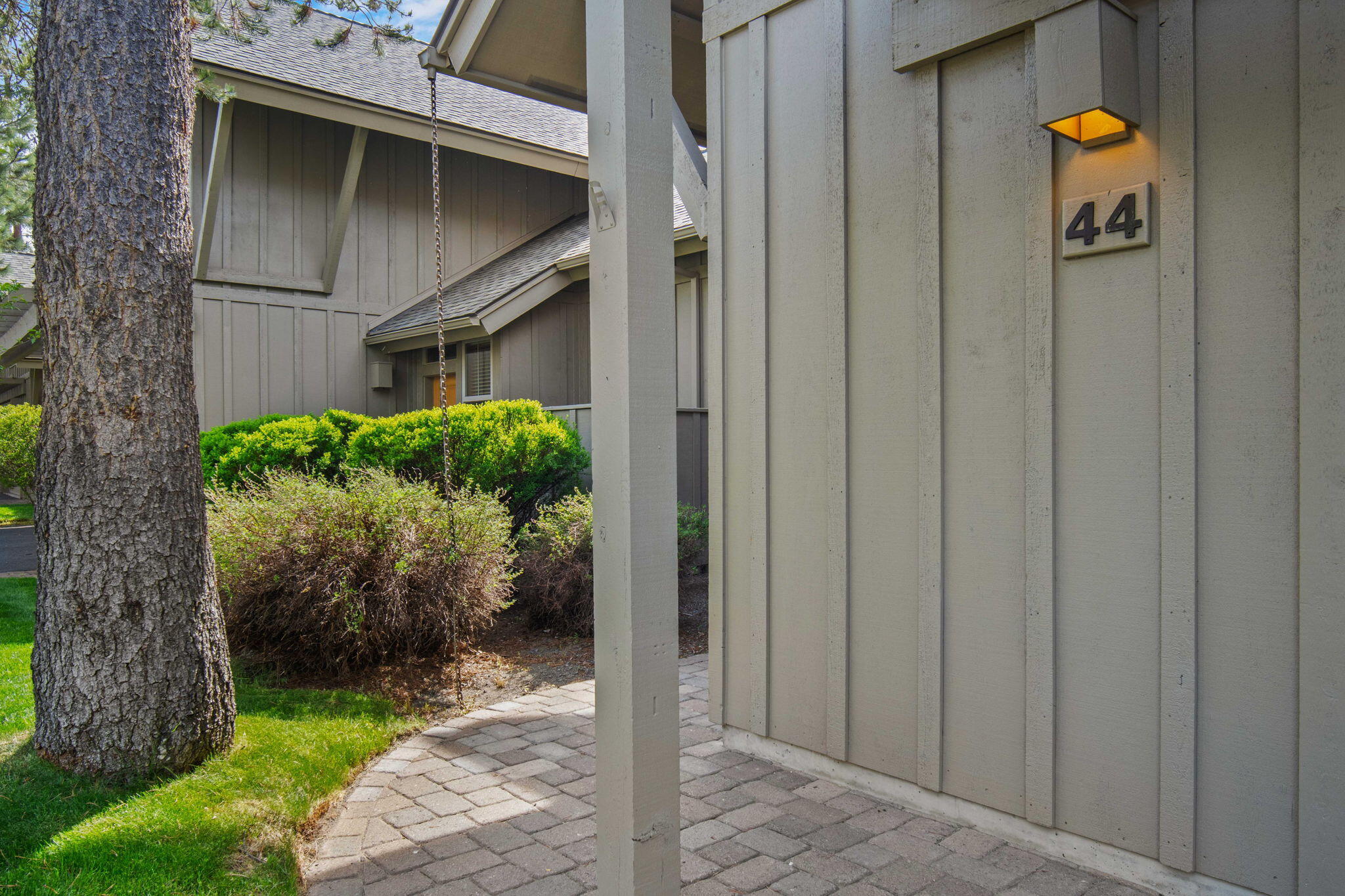 57129 Evergreen Loop, Unit 44 Sunriver, OR 97707 - Photo 11 of 59 a backyard of a house with potted plants and a tree