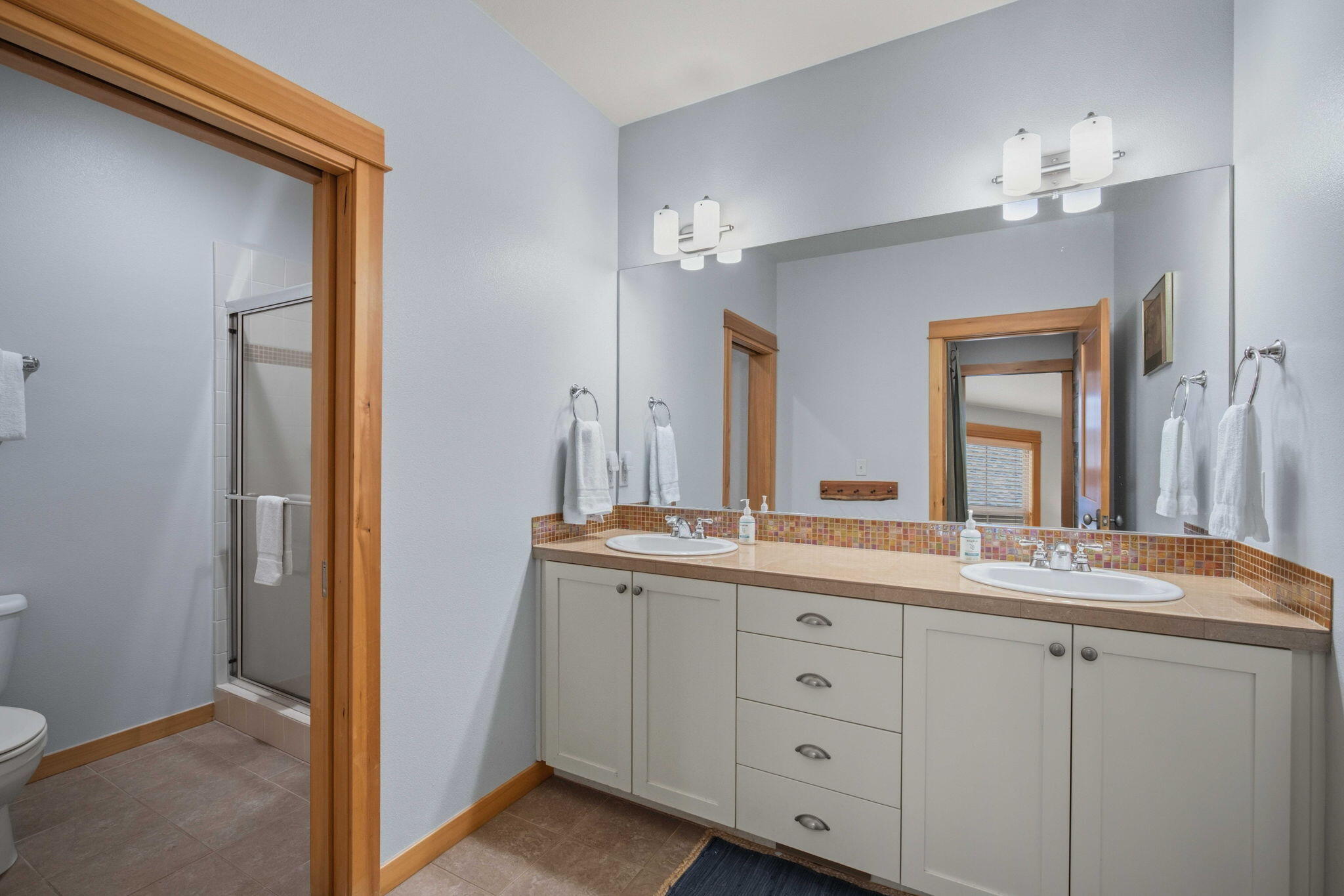 57129 Evergreen Loop, Unit 44 Sunriver, OR 97707 - Photo 30 of 59 a bathroom with a double vanity sink and a mirror