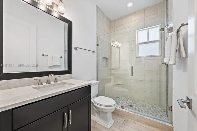 a bathroom with a sink a toilet and shower