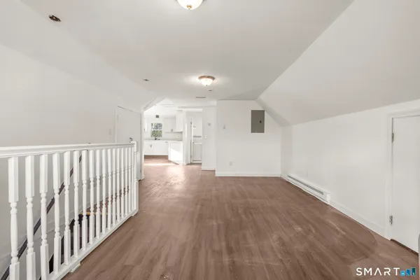 a kitchen with white cabinets and wooden floor