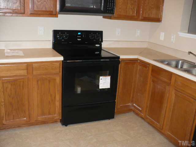 3406 Sosa Road Raleigh, NC 27610 - Photo 3 of 16 a kitchen with a sink and a refrigerator